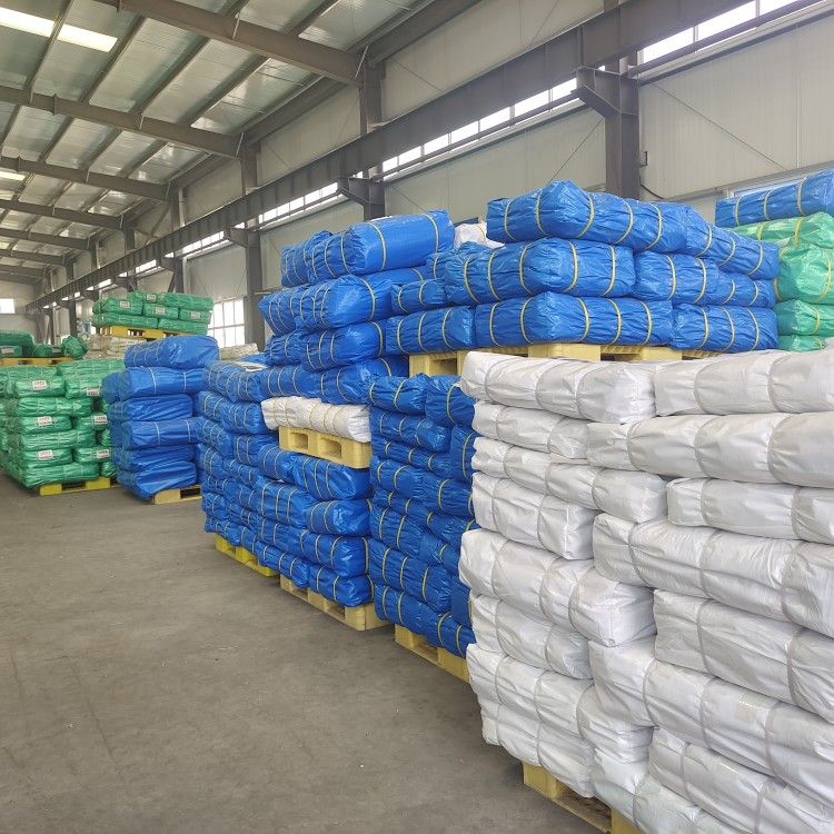 A.S. Tarpaulins distribution warehouse: colour-coded bulk tarpaulin bundles stacked on pallets, ready for dispatch